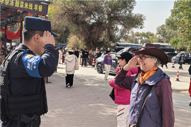 10月16日，北京游客窦奶奶和轮台县公安局民警在塔里木胡杨林公园双向致敬表示感谢。张尧 摄