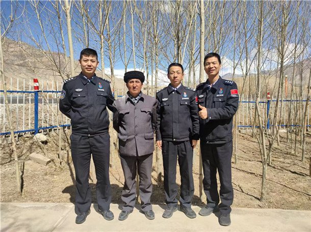 图为何超（右二）在基层走访时与驻地老乡合影。何伟摄