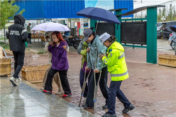 警在雨中搀扶拄双拐的群众通行。 警在雨中搀扶拄双拐的群众通行。