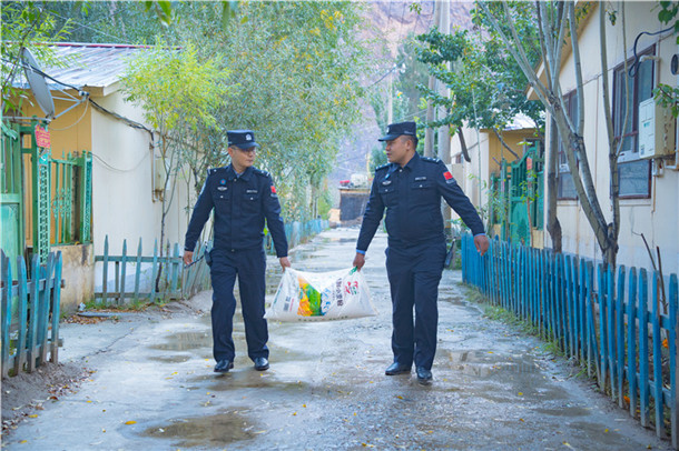 图为25日,库地边境检查站民警携带面粉前往驻地困难群众家中慰问。何伟摄 图为25日,库地边境检查站民警携带面粉前往驻地困难群众家中慰问。何伟摄