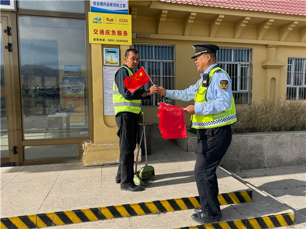 图三:执法人员向服务区从业人员发放小国旗 图三:执法人员向服务区从业人员发放小国旗